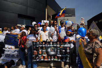 Венесуэльские протестующие поднимают транспаранты и