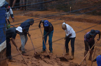 Люди сгребают грязь