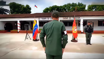 Белое здание с крышей в командовании зоны GNB Амазонас. Два офицера в форме, флаги Венесуэлы и еще один красный, а также громкоговоритель во внутреннем дворике.