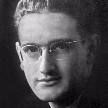 Черно-белый крупный план молодого человека в очках, темные волосы зачесаны назад и смотрит немного вправо.