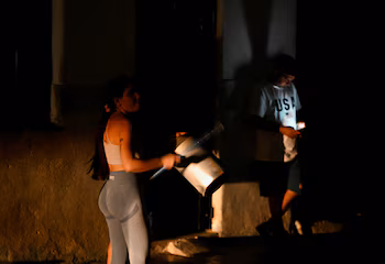 Люди делают касероласо во время отключения электроэнергии в Гаване, 7 марта (REUTERS/Norlys Pérez)